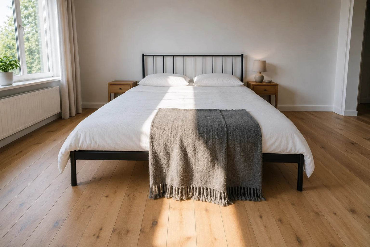 Bett in Überlänge mit 220 cm Liegefläche, aufgenommen vom Fußende, in einem hellen Schlafzimmer mit langem Lichtstreifen über die gesamte Bettlänge
