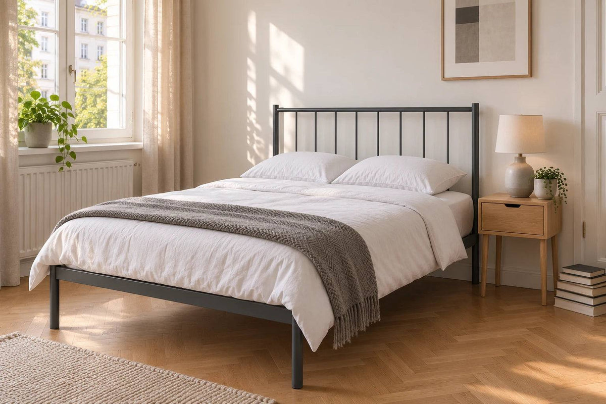 Metallbett 120 x 200 cm in dunkelgrau in einem kompakten Altbau-Schlafzimmer mit Fischgrätparkett, weißer Bettwäsche und minimalistischem Design