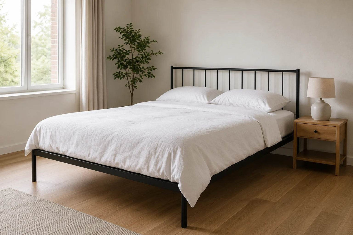 Metallbett 140 x 200 cm in schwarz in einem hellen Schlafzimmer mit natürlichem Morgenlicht, weißer Bettwäsche und minimalistischem Design