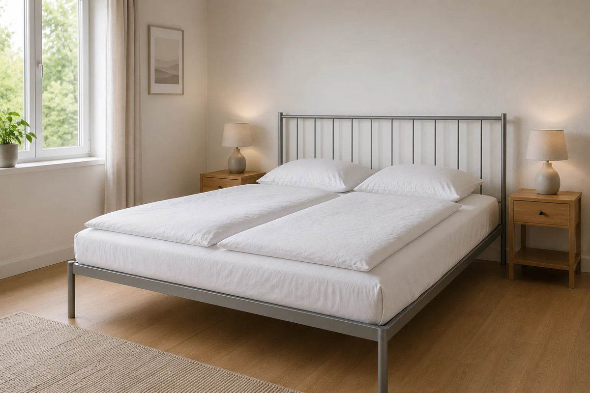 Metallbett 160 x 200 cm in silbergrau in einem hellen Schlafzimmer mit zwei Nachttischen, zwei separaten Bettdecken und natürlichem Licht