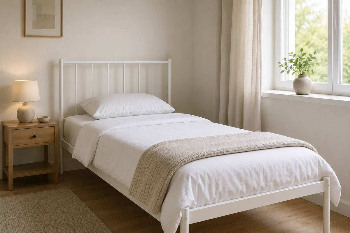 Metallbett 90 x 200 cm in weiß in einem hellen, kompakten Gästezimmer mit natürlichem Licht, weißer Bettwäsche und minimalistischem Design